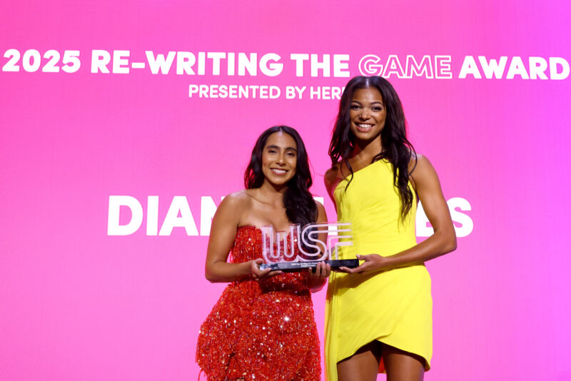 Diana Flores (L) accepts the Re-Writing the Game Award from Gabby Thomas (R) onstage during the 2025 Women's Sports Foundation's Annual Salute To Women In Sports awards gala.
